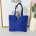 Detail of royal blue canvas tote bag featuring a gold metal snap button and thick handles - 8oz - Snap Button Style / Sapphire Blue