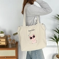 Close-up of a large capacity canvas tote bag with cartoon embroidery and drawstring detail - Gray
