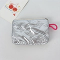 Detail of silver metallic pouch with 3D embossed bows and pink lanyard attachment - Small Bow Silver