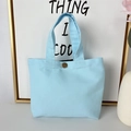 Detail of light blue canvas tote bag showing thick fabric texture and bronze metal snap button - 8oz - Snap Button Style / Blue