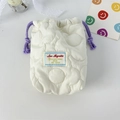 Dettaglio della custodia trapuntata crema con coulisse viola e texture morbida e fine - Fiore Trapuntato Bianco