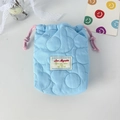 Close-up of light blue quilted drawstring camera bag with Love Mayrabbit woven label - Quilted Flower Blue