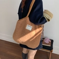Brown faux shearling large tote bag with SEEYOU patch shown on model in warm lighting - Striped Label Reversible Tote / Brown Coffee Reversible
