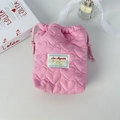 Close-up of pink heart-quilted drawstring bag with padded fabric on white desktop - Quilted Heart Pink