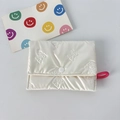 Detailed view of white quilted pouch with embossed bow pattern and pink elastic loop - Small Bowknot Cream White