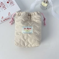 Detail of heart-quilted beige drawstring pouch with pink cords and woven logo label - Khaki