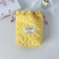 Detail of yellow heart-quilted drawstring pouch with soft padding and pink cord - Yellow