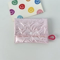Detailansicht des gesteppten Herzmusters auf glänzender rosa Kosmetiktasche aus Satin - Herz Rosa