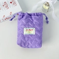 Purple heart-quilted drawstring storage bag with decorative label in a cozy setting - Quilted Heart Purple