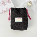 Detail of heart quilted cosmetic pouch featuring pink drawstrings and small woven label - Quilted Heart Black