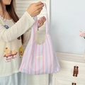 Macro detail of rainbow striped tote bag with pastel pink and blue texture and brand tag - Pink Purple Stripes