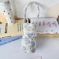 Close-up of quilted floral water bottle holder with soft cotton padding and handle - Blue Flower