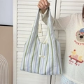 Detail of colorful seersucker tote bag showing rainbow stripes and mayrabbit brand tag - Green Purple Stripes