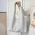 Detail of grey striped tote bag in seersucker fabric with rectangular woven label - Small Grey Plaid