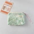 Close-up of green floral lace cosmetic pouch with fuzzy fabric texture and zipper detail - Green Daisy