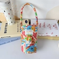 Close-up of quilted cotton water bottle carrier with colorful cartoon bear and rainbow prints - Graffiti