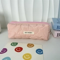 Détail de la texture matelassée rose et de l'étiquette tissée May Rabbit sur la trousse - Polyester Floral Rose