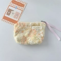 Detail van een gele bloemen kant portemonnee met roze lint rits en merknaam label - Geel Madeliefje