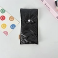 Detailed view of black quilted pencil case with bow texture and button closure - Small Bowknot Black
