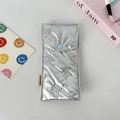 Close-up of silver quilted puffy pouch with butterfly pattern and blue snap button - Small Bow Silver