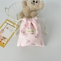 Detail of pink floral corduroy drawstring pouch with logo tag in cozy setup - Pink Floral