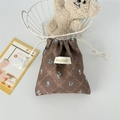 Detailed view of a brown corduroy drawstring pouch with blue floral print and logo label - Brown Diamond Lattice Flower
