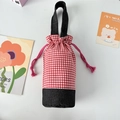 Detail of red checkered water bottle pouch with black base and drawstring closure - Red Plaid