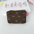Detail of brown corduroy pouch featuring white bow patterns and a silver metal zipper - Brown Bowknot