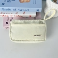 Detail of a cream corduroy stationery pouch showing the May Rabbit label and hand strap - Creamy White
