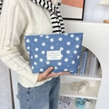 Blue denim clover pattern makeup bag held by a model in a cozy lifestyle setting - Light Blue Clover