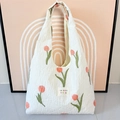 Detailansicht der roten Tulpenstickerei auf der weiß plissierten Tragetasche - Westen-Stil Tasche