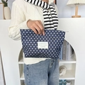 Close-up of navy canvas makeup bag with white stars and stylish woven label detail - Dark Blue Stars