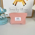 Detailed view of pink waffle fabric texture and metal zipper on the cosmetic pouch - Pink