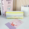 Detailed view of the pleated striped fabric texture and silver zipper pull on the pencil case - Yellow Purple Stripe