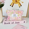 Macro detail of pink floral chiffon cosmetic bag with soft texture and chic brand label - Pink Daisy