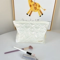 Macro detail of white pearl finish PU leather with heart quilted pattern and zipper - Heart Creamy White