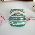 Macro detail of a green knit earphone case with a pink cord and beaded lanyard - Green