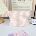 Pink striped fabric cosmetic bag with letter patch in a cozy home setting decor - Pink White Stripes