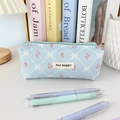 Macro detail of blue corduroy pencil case featuring quilted floral pattern and logo tag - Blue Plaid Bow