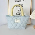 Dettaglio della borsa trapuntata azzurra con manici gialli e etichetta del logo - Zucca Blu Trapuntata (Manico Giallo)