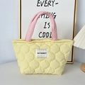 Borsa a mano trapuntata gialla con manici rosa e logo May Rabbit su tavolo bianco - Zucca Gialla Trapuntata (Manico Rosa)