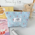 Dettaglio ravvicinato della trousse in velluto a coste blu con motivi floreali e zip - Fiocco a Quadri Blu