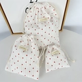Detail showing set of three striped heart drawstring bags with textured fabric and labels - Large / Striped Red Heart