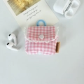 Detail view of pink plaid fabric earphone case with white lace trim and blue clip - Small Pink Grid