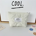 Detail of cream quilted cosmetic bag with floral stitching and branded woven label - Quilted Flower White
