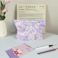 Neceser de peluche con estampado floral, borla y etiqueta en un entorno elegante - Margarita Púrpura