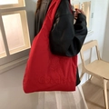 Vibrant red large nylon tote bag with Never Say Goodbye embroidery shown on model - Red