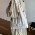 White minimalist nylon tote bag with Never Say Goodbye embroidery on a model - Beige
