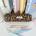 Detailopname van corduroy etui met luipaardprint en kantoortoebehoren op een bureau - Bruine Luipaard