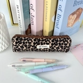 Detail van corduroy etui met luipaardprint, bruine rits en een wit geweven stoffen label - Khaki Luipaard